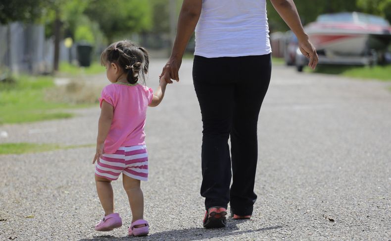 Una mujer, quien dijo que ingresó al país de forma ilegal, camina con su hija, quien nació en Estados Unidos pero a la que se le negó el acta de nacimiento, el 16 de septiembre de 2015, en Sullivan City, Texas. (AP Foto/Eric Gay, Archivo)