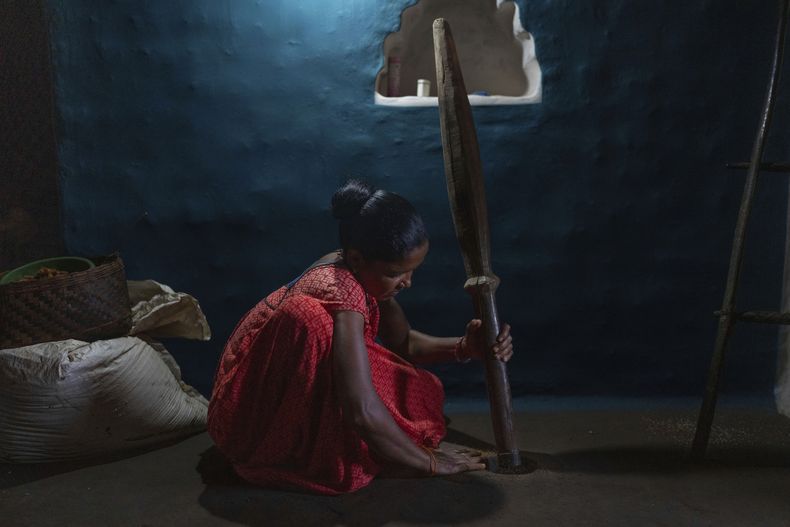Una mujer de la comunidad indígena gadaba muele mijo en la aldea de Badakichaba, en el estado de Odisha, India, el viernes 18 de abril de 2025. (AP Foto/Rafiq Maqbool)