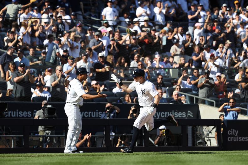 Ben Rice de los Yankees de Nueva York saluda al coach de tercera base Luis Rojas luego de batear un jonrón ante los Orioles de Baltimore, el domingo 28 de septiembre de 2025, en Nueva York. (AP Foto/Pamela Smith)