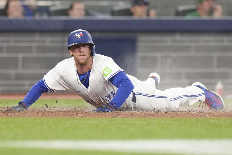 Myles Straw, de los Azulejos de Toronto, anota carrera con un sencillo productor de su compañero Joey Loperfidfrente al lanzador de los Angelinos de Los Ángeles, Tyler Anderson, durante la cuarta entada del juego de béisbol de Grandes Ligas el domingo 6 de julio de 2025, en Toronto. (Chris Young/The Canadian Press vía AP)