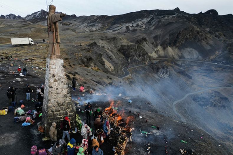 Personas se reúnen para quemar ofrendas a la Pachamama, o Madre Tierra, durante un antiguo ritual para pedir una buena cosecha en La Cumbre, una montaña sagrada a las afueras de La Paz, Bolivia, el sábado 1 de agosto de 2026. (Foto AP/Juan Karita)