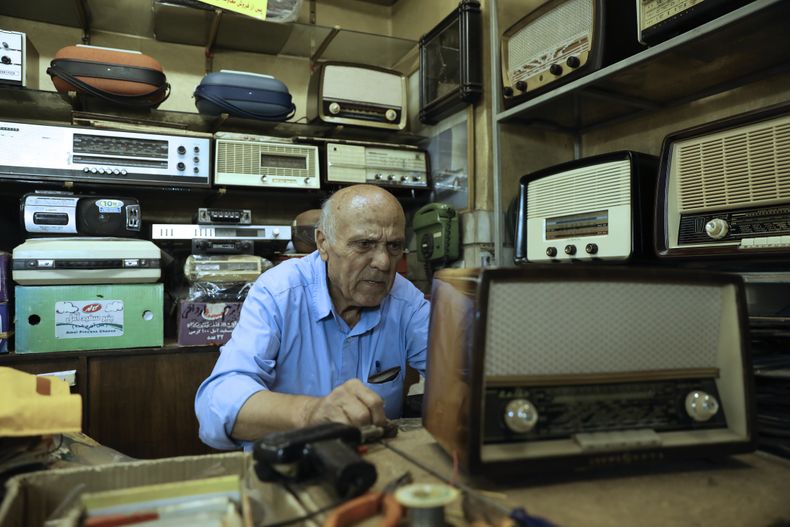 Reza Alimirzaei, de 73 años, que repara y vende radios viejas, trabaja en su tienda en el centro de Teherán, Irán, el miércoles 18 de septiembre de 2024. (Foto AP/Vahid Salemi)