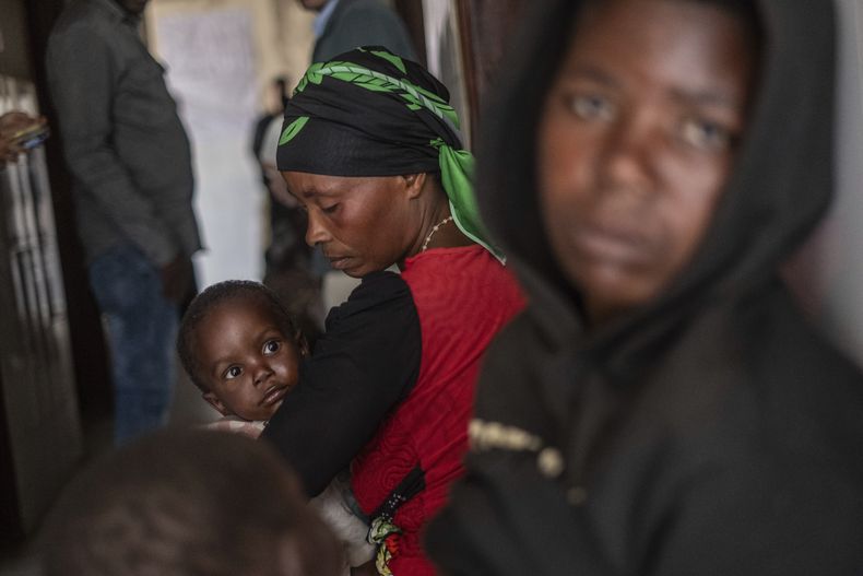 Residentes escuchan a Tom Fletcher, subsecretario general de Asuntos Humanitarios y Alivio de Emergencias de la Oficina de Coordinación de Asuntos Humanitarios (OCHA, por sus siglas en inglés) de la ONU, en su visita al poblado de Buhumba en Kivu del Norte, República Democrática del Congo, el jueves 26 de junio de 2025. (AP Foto/Moses Sawasawa)