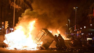 Manifestantes incendian contenedores de basura durante enfrentamientos con la policía tras una manifestación por la crisis de vivienda en España, en Barcelona, España, el lunes 5 de octubre de 2026, horas después de que el presidente de gobierno Pedro Sánchez anunciara elecciones generales anticipadas. (AP Foto/Emilio Morenatti)
