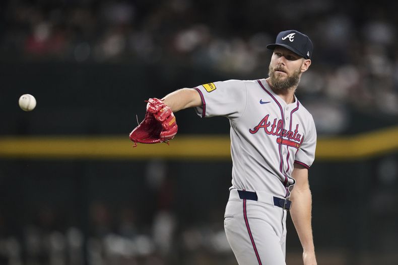 El lanzador abridor de los Bravos de Atlanta, Chris Sale, extiende la mano para una pelota nueva durante la segunda entrada de un juego de béisbol contra los Diamondbacks de Arizona, el viernes 25 de abril de 2025, en Phoenix. (AP Foto/Ross D. Franklin)