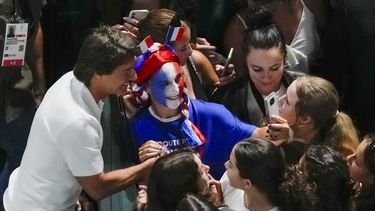 El actor Tom Cruise, izquierda, se toma fotos con fans mientras asiste a la ronda de clasificación de gimnasia artística femenina en los Juegos Olímpicos de Verano de 2024, el domingo 28 de julio de 2024, en París, Francia. (Foto AP/Morry Gash)