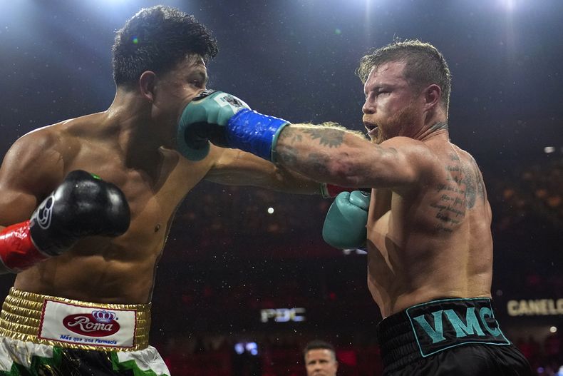 ARCHIVO - El mexicano Saúl Canelo Álvarez propina un golpe a Jaime Munguía durante su pelea en la división de los supermedianos, el 4 de mayo de 2024, en Las Vegas (AP Foto/John Locher, archivo)