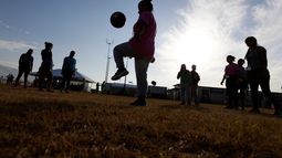 ARCHIVO - Personas juegan fútbol en un centro de detención del gobierno de EE.UU. para niños migrantes, en Carrizo Springs, Texas, el 9 de julio de 2019. (AP Foto/Eric Gay/Archivo)