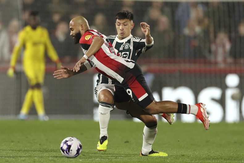 Bryan Mbeumo del Brentford cae tras ser tacleado por Lisandro Martínez del Manchester United en el encuentro de la Liga Premier el sábado 30 de marzo del 2024. (AP Foto/Ian Walton)