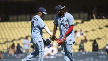 Whit Merrifield (izquierda) y el dominicano Vladimir Guerrero Jr., de los Azulejos de Toronto, festejan la victoria sobre los Dodgers de Los Ángeles, el miércoles 26 de julio de 2023 (AP Foto/Kyusung Gong)