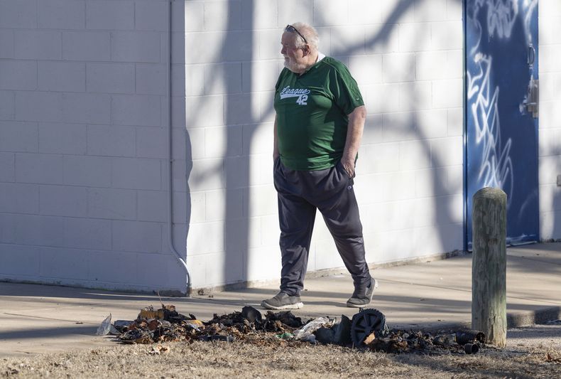 Bob Lutz, director ejecutivo de Liga 42, una liga de béisbol juvenil en Wichita, Kansas, camina junto a los restos carbonizados de un contenedor de basura donde la policía de Wichita encontró piezas de una estatua robada de Jackie Robinson el martes 30 de enero de 2024. La estatua de tamaño natural de Jackie Robinson fue cortada por los tobillos del campo de béisbol de la Liga 42 el 25 de enero. La policía no ha realizado arrestos en el caso, pero dijo el martes que la estatua estaba dañada sin posibilidad de reparación. (Travis Heying/The Wichita Eagle vía AP)
