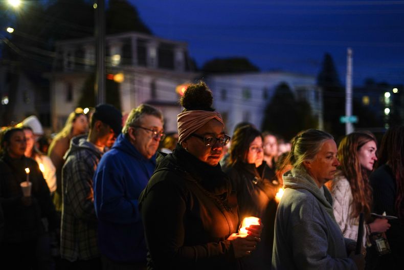 ARCHIVO - Un grupo de personas se congrega para una vigilia para las víctimas de un tiroteo masivo, el domingo 29 de octubre de 2023, afuera de la Basílica de San Pedro y San Pablo en Lewiston, Maine. (AP Foto/Matt Rourke, archivo)