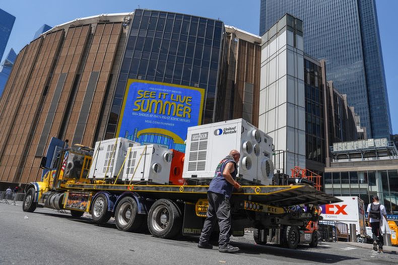 Un trabajador descarga unidades de aire acondicionado portátiles afuera del Madison Square Garden antes de la reportada boda entre la cantante Taylor Swift y el jugador de la NFL Travis Kelce, el jueves 2 de julio de 2026, en Nueva York. (Foto AP/Ryan Murphy)