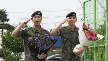 Los miembros de la banda de K-pop BTS, RM, a la izquierda, y V saludan después de ser dados de baja del servicio militar obligatorio en Chuncheon, Corea del Sur, el martes 10 de junio de 2025. (Foto AP/Ahn Young-joon)