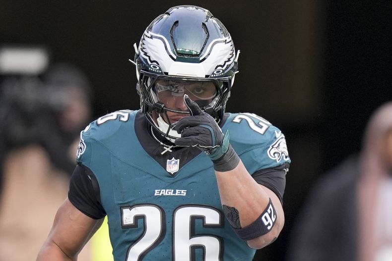 El corredor de los Eagles de Filadelfia Saquon Barkley celebra tras anotar en el encuentro ante los Commanders de Washington el domingo 26 de enero del 2025. (AP Foto/Chris Szagola)