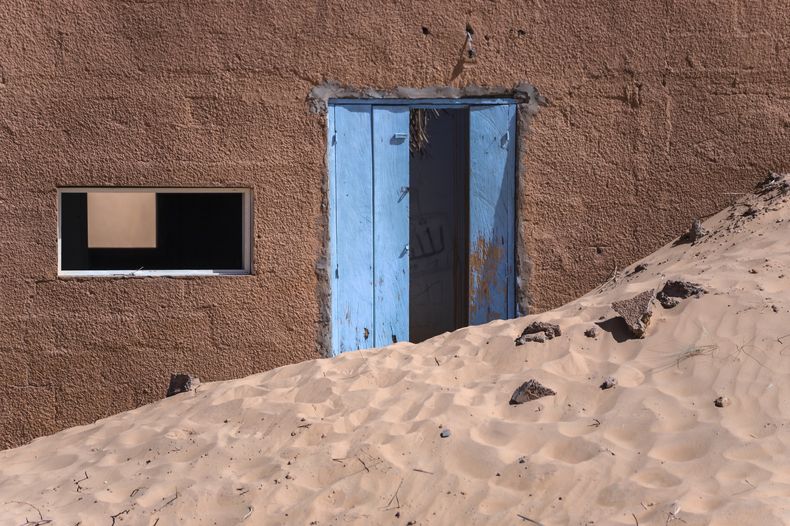 Una vivienda se encuentra abandonada en medio de la arena cerca de Chingueti, Mauritania, el 13 de enero de 2025. (AP Foto/Khaled Moulay)