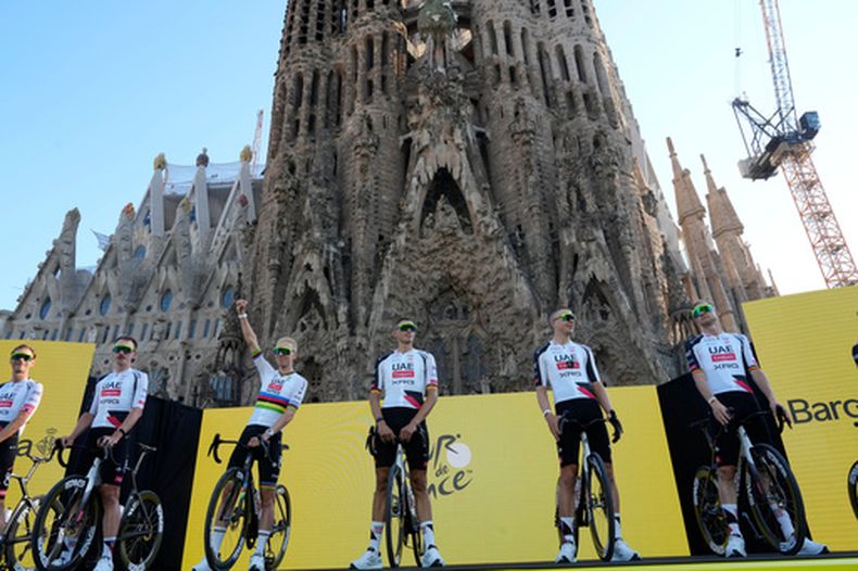 Tadej Pogačar saluda a la multitud mientras el UAE Team Emirates es presentado antes de la carrera ciclista del Tour de Francia, frente a la Basílica de la Sagrada Familia en Barcelona, España, el jueves 2 de julio de 2026. (Foto AP/Mosaab Elshamy)