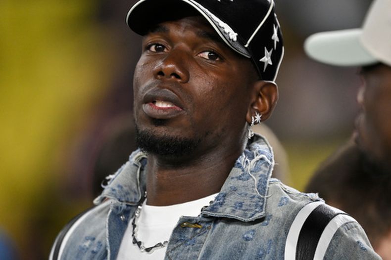 ARCHIVO: El jugador del Mónaco, Paul Pogba, permanece de pie en la línea banda mientras los jugadores calientan antes de un partido de la fase inicial de la Liga de Campeones entre el Mónaco y el Tottenham Hotspur en Mónaco, el miércoles 22 de octubre de 2025. (Foto AP/Philippe Magoni, archivo)