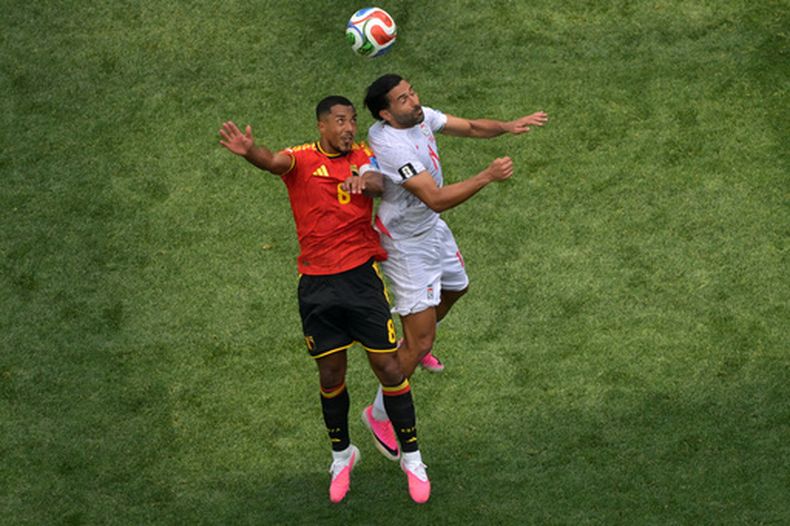 El belga Youri Tielemans (8) y el iraní Saman Ghoddos (14) se disputan un balón durante su partido por el Grupo G del Mundial entre Bélgica e Irán, el domingo 21 de junio de 2026, en Inglewood, California. (AP Foto/Jayne Kamin-Oncea)