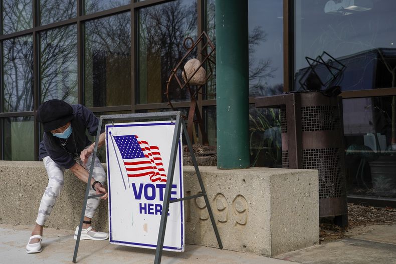 ARCHIVO- La trabajadora electoral Pranee Sheskey coloca un cartel fuera del Warner Park Community Recreation Center para el primer día de votación anticipada el martes 21 de marzo de 2023, en Madison, Wisconsin. (AP Foto/Morry Gash, Archivo)