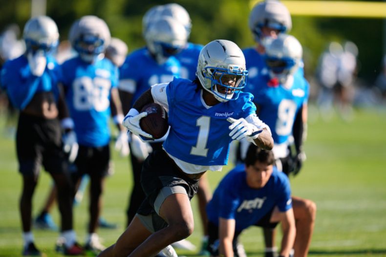 El receptor de los Lions de Detroit Jameson Williams corre tras atrapar un balón en la práctica del equipo del miércoles 29 de julio del 2026. (AP Foto/Paul Sancya)