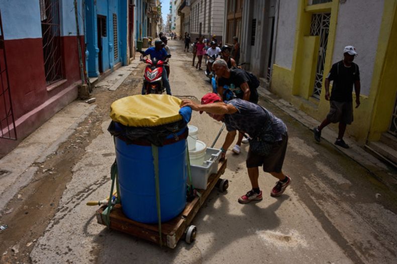 Unas personas transportan bidones de agua en La Habana, el miércoles 27 de mayo de 2026. (Foto AP/Ramón Espinosa)