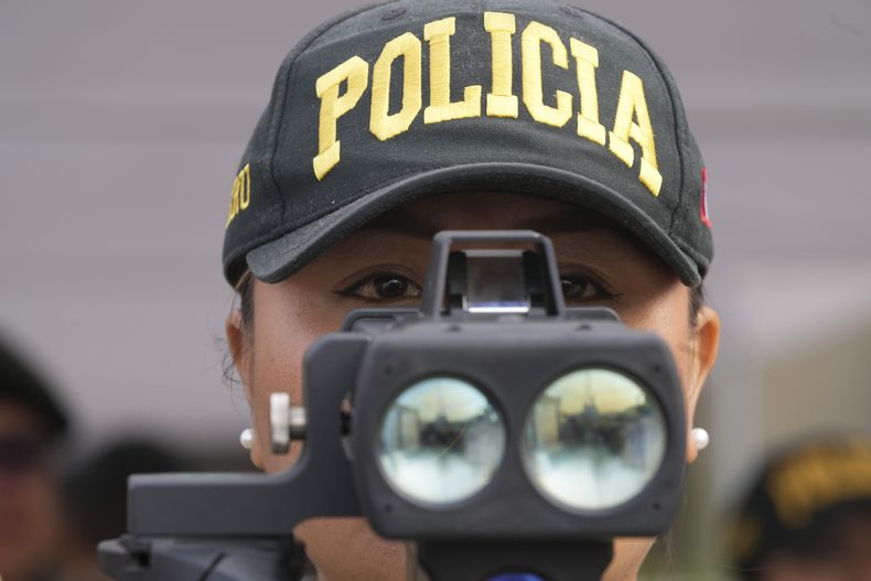 Una agente de policía vigila durante una presentación del equipo de seguridad por la reunión del Foro de Cooperación Económica Asia-Pacífico (APEC, por sus siglas en inglés, en el Ministerio de Cultura, en Lima, Perú, el 11 de noviembre de 2024. (AP Foto/Silvia Izquierdo)