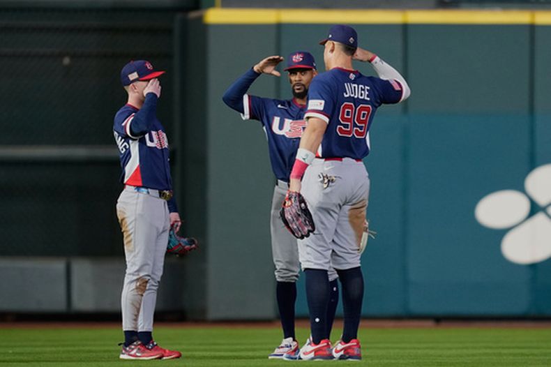 Aaron Judge (99) celebra con Brice Turang (izquierda) y Byron Buxton (centro) tras la victoria de Estados Unidos sobre Canadá en los cuartos de final del Clásico Mundial, el viernes 13 de marzo de 2026, en Houston. (AP Foto/David J. Phillip)