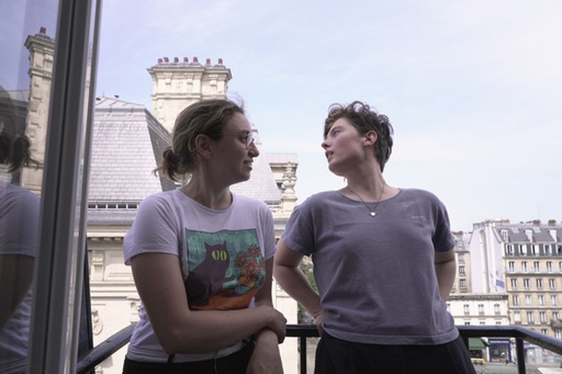 Amelie Kenney, a la derecha, y su pareja Francesca Pilia posan en el balcón del ático que comparten, el martes 23 de junio de 2026, en París. (AP Foto/John Leicester)