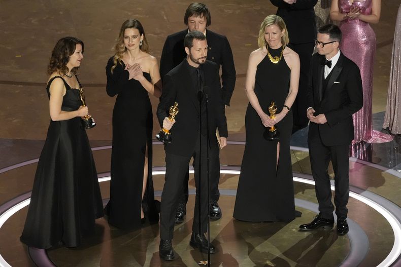 Raney Aronson-Rath, de izquierda a derecha, Vasilisa Stepanenko, Mstyslav Chernov, Evgeniy Maloletka, Michelle Mizner, y Derl McCrudden reciben el premio a mejor largometraje documental por 20 Days in Mariupol en los Oscar el domingo 10 de marzo de 2024, en el Teatro Dolby en Los Ángeles. (Foto AP/Chris Pizzello)