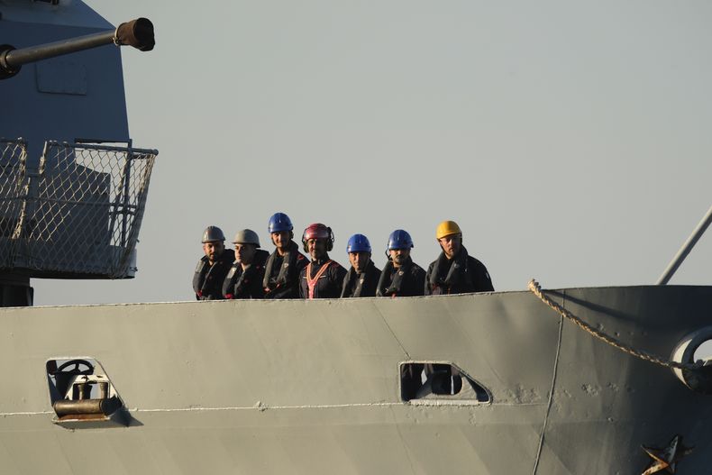 Personal de seguridad, en la cubierta del buque de la Armada italiana Libra a su llegada al puerto de Shengjin, en el noroeste de Albania, el 16 de octubre de 2024, con el primer grupo de migrantes interceptados por Italia en aguas internacionales que son enviados a Albania. (AP Foto/Vlasov Sulaj)