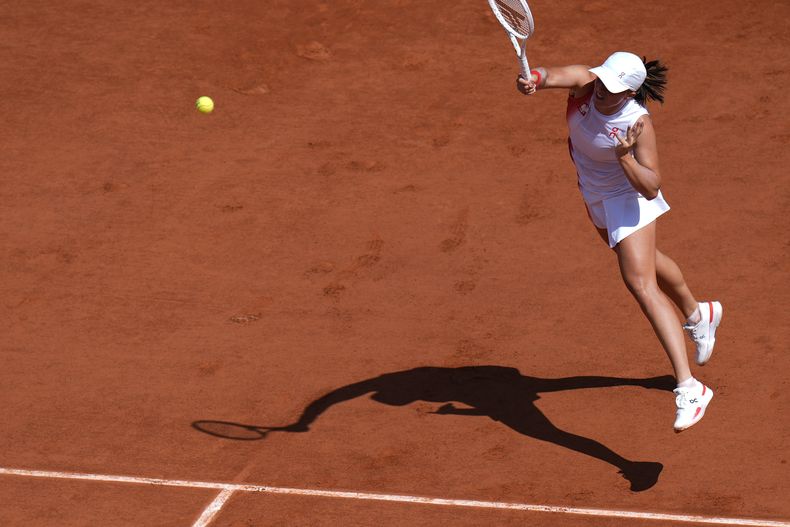 La polaca Iga Swiatek devuelve un golpe de la china Zheng Qinwen durante su partido de semifinales en el torneo olímpico, el jueves 1 de agosto de 2024, en París. (AP Foto/Andy Wong)