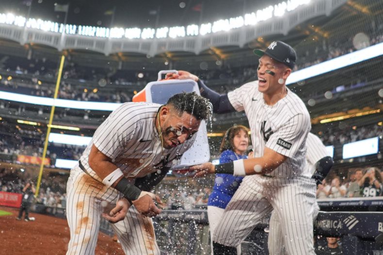 Aaron Judge (derecha) festeja co el panameño José Caballero, su compañero en los Yankees de Nueva York, quien conectó el hit de la victoria sobre los Angelinos de Los Ángeles, el miércoles 15 de abril de 2026 (AP Foto/Frank Franklin II)