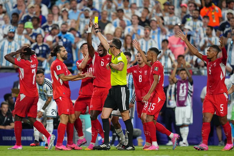 Los jugadores de Suiza discuten con el árbitro portugués Joao Pinheiro, quien muestra una segunda tarjeta amarilla a Breel Bemolo (7) en el partido de cuartos de final de la Copa del Mundo ante Argentina, el sábado 11 de junio de 2026, en Kansas City, Missouri (AP Foto/Ed Zurga)