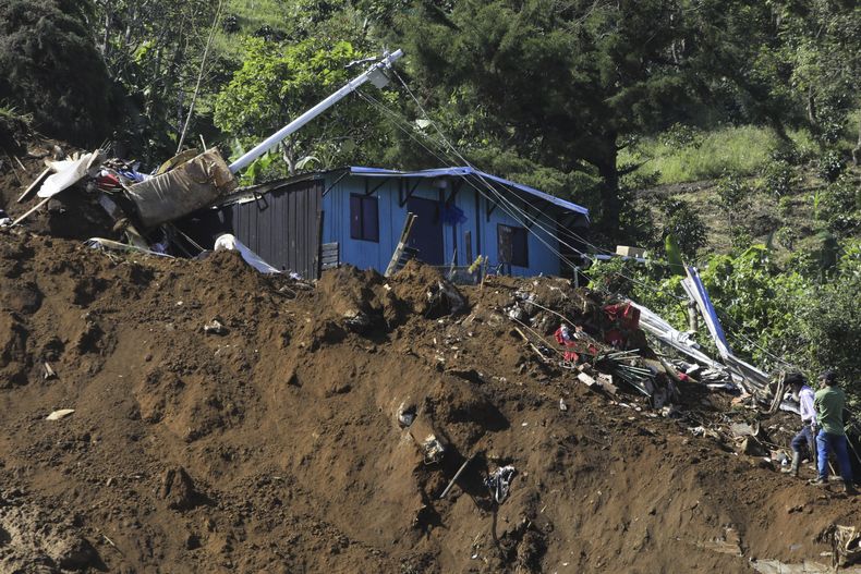 Personas observan su casa destruida tras un deslizamiento de tierra mortal provocado por fuertes lluvias en Bello, Antioquia, Colombia, el miércoles 25 de junio de 2025. (Foto AP/Fredy Amariles)