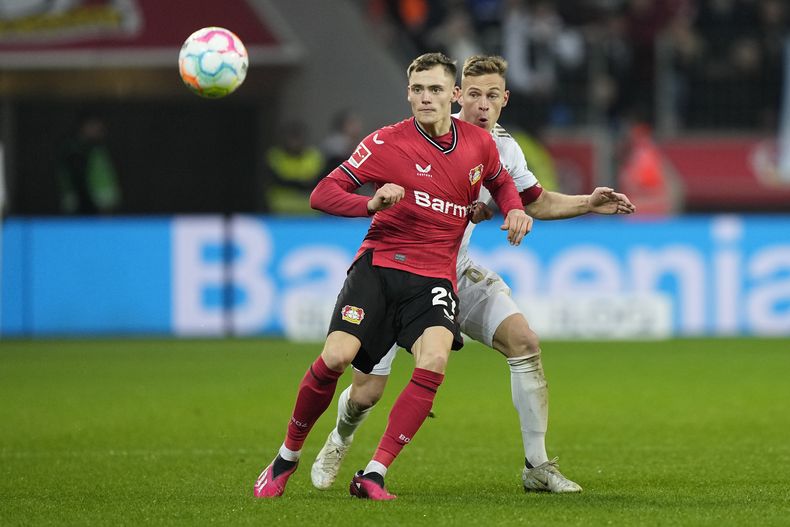 ARCHIVO - Florian Wirtz (izquierda), del Bayer Leverkusen, disputa un balón con Joshua Kimmich, del Bayern Múnich, en un partido de la Bundesliga disputado el 19 de marzo de 2023 (AP Photo/Martin Meissner, archivo)