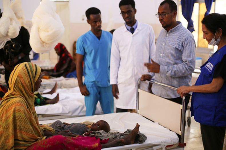 Trabajadores de la salud hablan con una mujer con un hijo desnutrido en el Hospital Infantil en Baidoa, Somalia, el 4 de agosto de 2026. (AP Foto/Mohamed Sheikh Nor)