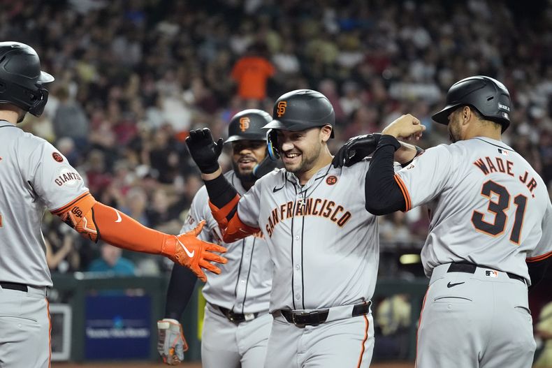 Michael Conforto (centro), de los Gigantes de San Francisco, festeja tras conectar un jonrón de tres carreras ante los Diamondbacks de Arizona, el martes 24 de septiembre de 2024 (AP Foto/Ross D. Franklin)