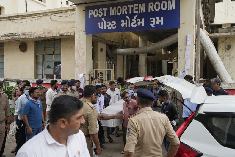Voluntarios y personal hospitalario sacan el ataúd de una víctima del accidente de un avión de Air India de la sala de autopsias de un hospital en Ahmedabad, India, el 13 de junio de 2025. (AP Foto/Rafiq Maqbool)