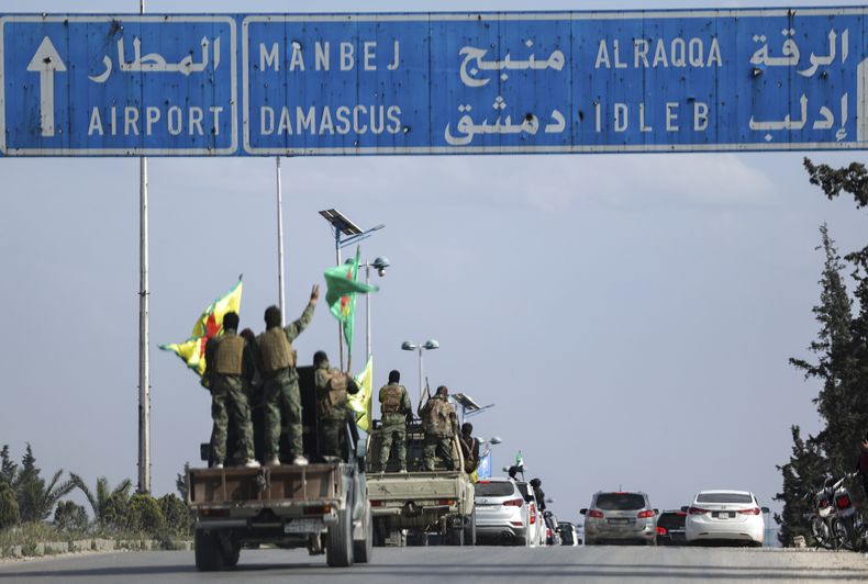 Combatientes kurdos respaldados por Estados Unidos a bordo de vehículos mientras se retiran de dos vecindarios en la ciudad de Alepo, en el norte de Siria, como parte de un acuerdo con el gobierno central de Siria, el viernes 4 de abril de 2025, en Alepo, Siria. (AP Foto/Ghaith Alsayed)