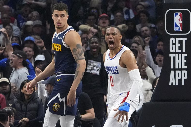 Russell Westbrook, base de los Clippers de Los Ángeles, festeja tras lograr una clavada, junto a Michael Porter Jr., de los Nuggets de Denver, el jueves 4 de abril de 2024 (AP Foto/Mark J. Terrill)