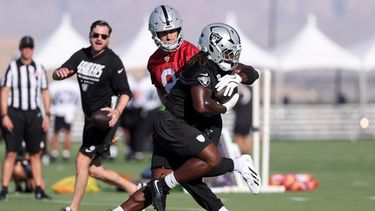 Kirk Cousins (8), quarterback de los Raiders de Las Vegas, entrega el balón al running back Ashton Jeanty (2) durante una práctica del equipo en el campaoento de entrenamiento, el jueves 30 de julio de 2026, en Henderson, Nevada. (AP Foto/Ian Maule)