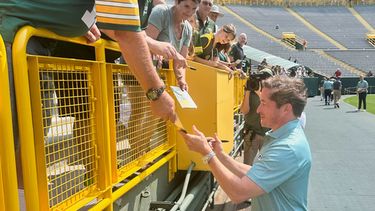 El presidente y director ejecutivo de los Packers de Green Bay Ed Policy, derecha, firma autógrafos a fanáticos después de la reunión anual de accionistas del equipo, el lunes 27 de julio de 2026, en el estadio Lambeau Field, en Green Bay, Wisconsin. (AP Foto/Steve Megargee)
