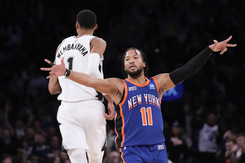Jalen Brunson, de los Knicks de Nueva York, festeja tras encestar, detrás de Victor Wembanyama, de los Spurs de San Antonio, el miércoles 8 de noviembre de 2023 (AP Foto/Seth Wenig)
