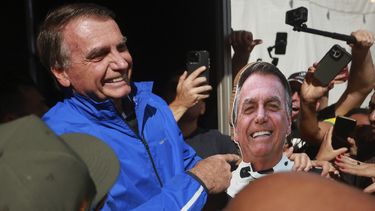 El expresidente brasileño Jair Bolsonaro señala a una foto de él el 29 de julio de 2025, en Brasilia. (AP foto/Luis Nova)