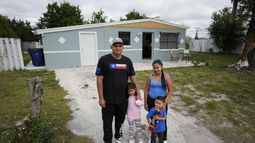 Alexis Llanos, a la izquierda, su pareja Diomaris Barboza, y sus hijos Alexa, de 7 años, y Alexis, de 3, posan el 27 de diciembre de 2023 para una foto afuera de la casa de Lehigh Acres, Florida, a la que se mudaron en octubre de 2023, cinco años después de haber salido de Venezuela hacia Colombia por amenazas de muerte. La de Llanos es una de las primeras familias de migrantes que llegaron a Estados Unidos legalmente bajo un nuevo programa conocido como Oficinas de Movilidad Segura, que busca agilizar el proceso de refugiados. (AP Foto/Rebecca Blackwell)