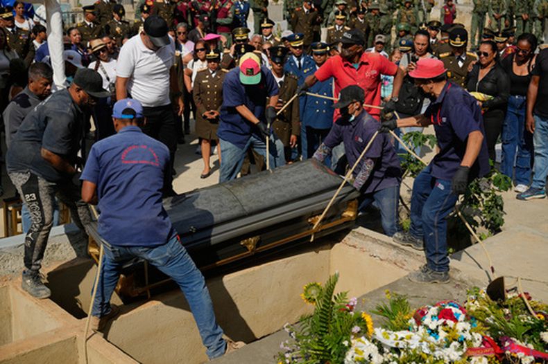 En esta foto del miércoles 7 de enero de 2026, los trabajadores de un cementerio de Caracas, Venezuela, bajan el ataúd de un soldado muerto en el ataque de EEUU para capturar al presidente venezolano Nicolás Maduro y a su esposa. (AP Foto/Ariana Cubillos)