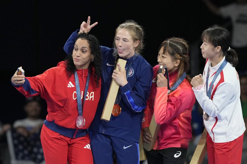 La cubana Yusneylis Guzmán, toma una foto de sí misma,, junto a la estadounidense Sarah Hildebrandt, la japonesa Yui Susaki y la china Ziqi Feng en el podio de la lucha libre, división de los 50 kilos, en los Juegos Olímpicos de París, el miércoles 7 de agosto de 2024 (AP Foto/Eugene Hoshiko)