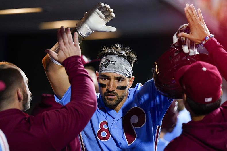 Nick Castellanos, de los Filis de Filadelfia, recibe felicitaciones luego de conectar un jonrón ante los Bravos de Atlanta, en el cuarto juego de la Serie de Campeonato de la Liga Nacional, el jueves 12 de octubre de 2023 (AP foto/Chris Szagola)