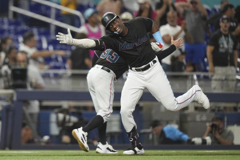 Jesús Sánchez, de los Marlins de Miami, celebra con el coach de tercera Jody Reed (33) mientras se enfila al plato después de un cuadrangular de tres carreras, en el juego de béisbol en contra de los Reales de Kansas City, el miércoles 7 de junio de 2023, en Miami. (AP Foto/Peter Joneleit)